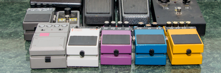 Two rows of guitar effects pedals on display