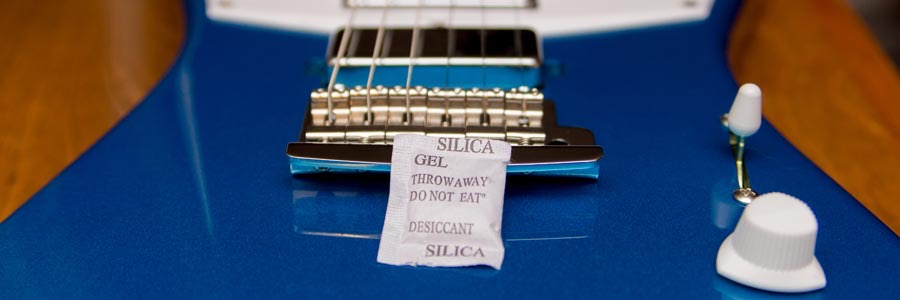 Photo of a silica gel packet on a guitar.
